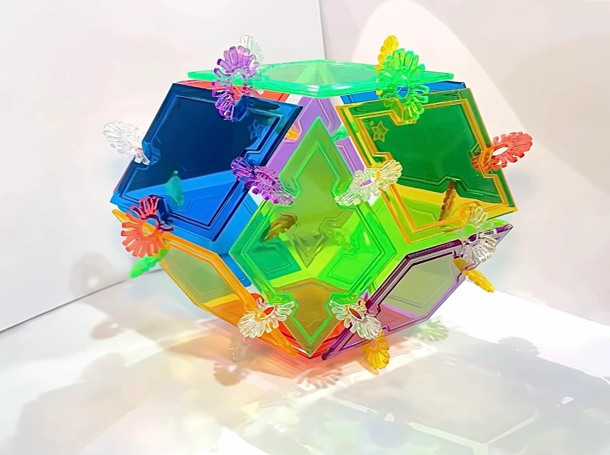 A transparent polyhedron with a turquoise top, large blue and green faces and colourful snowflake connectors.