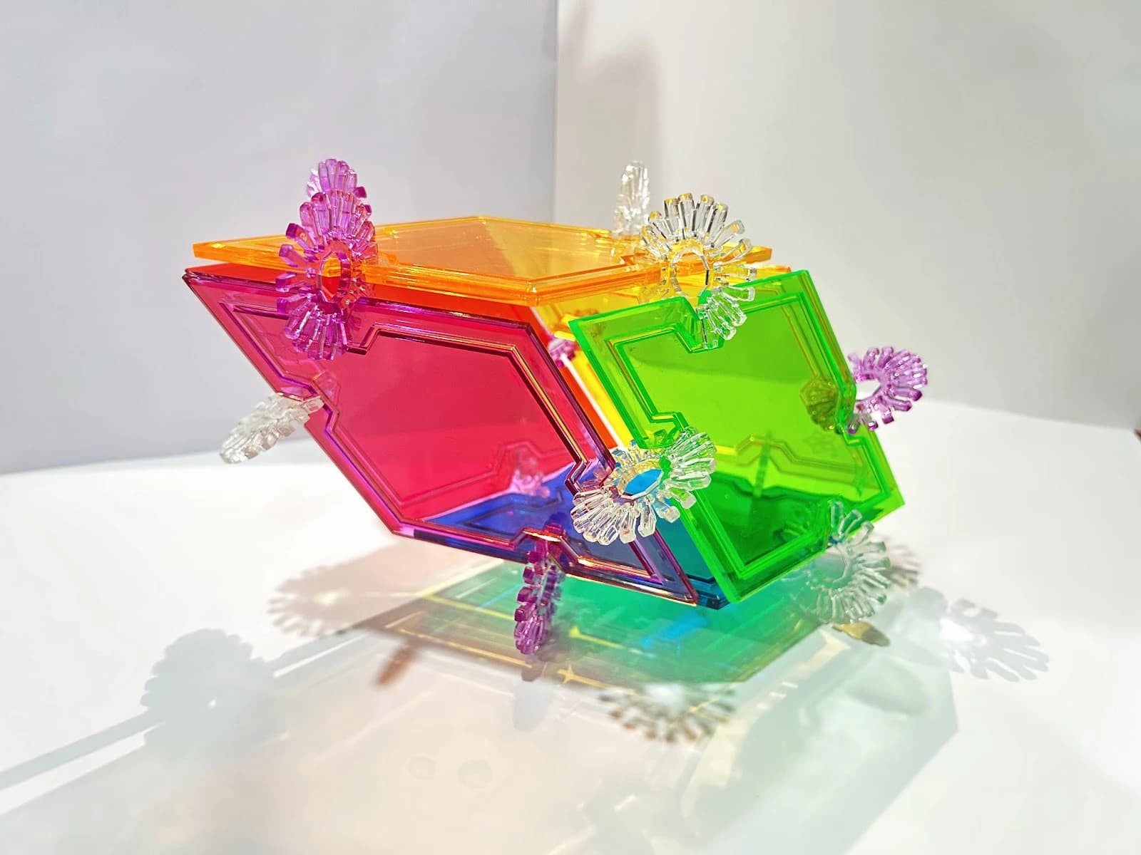 An elongated build with pink and green rhombus sides, an orange top and snowflake connectors.